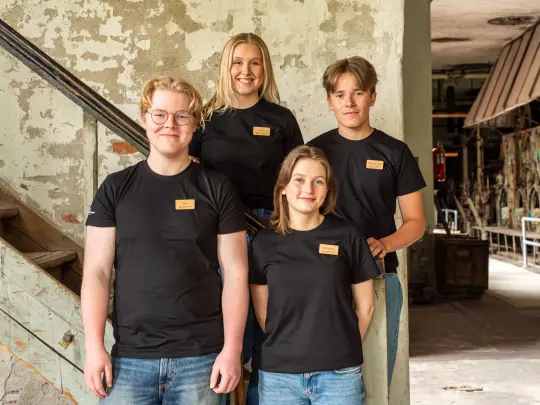 fire ungdommer i svart t-skjorte i fabrikkbygning